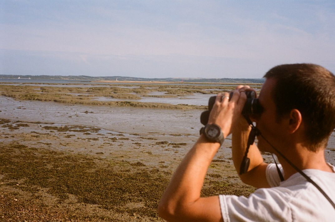 person with binoculars watching birds