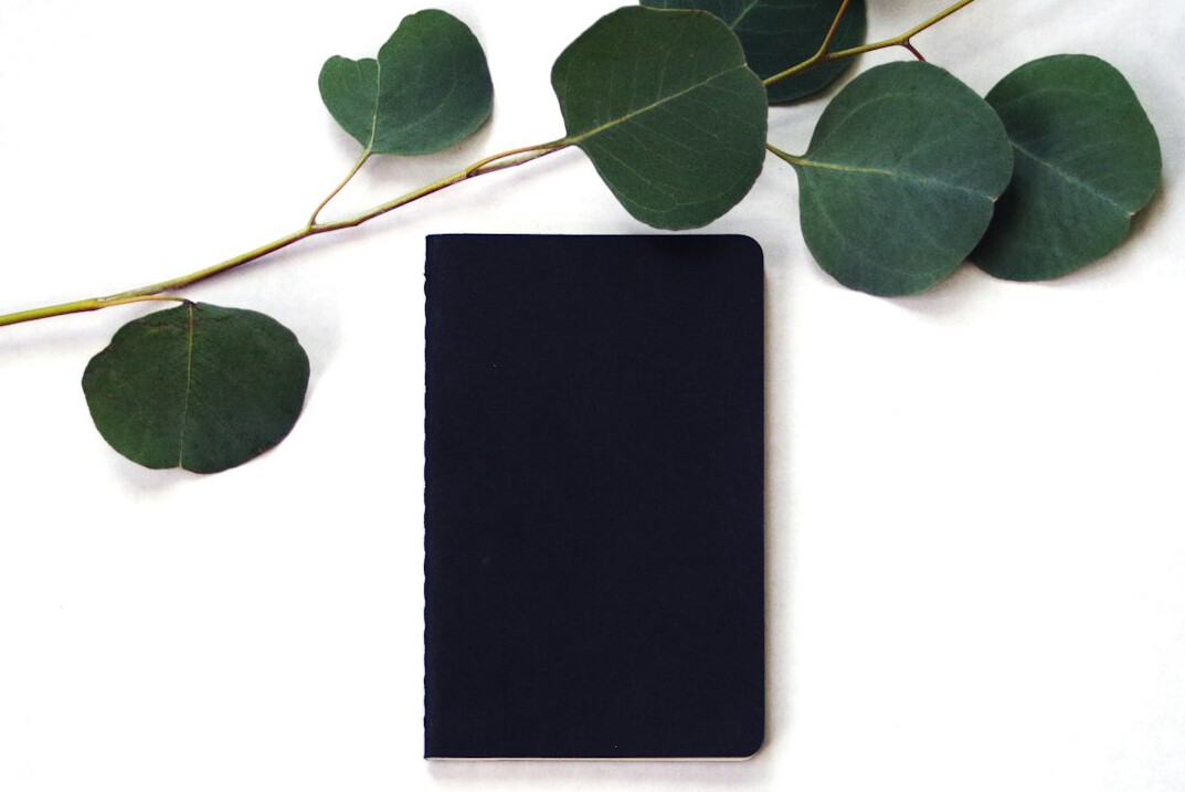 Open blank notebook with a pen on a table
