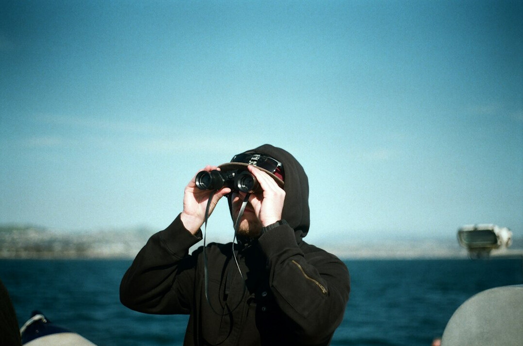 person with binoculars watching birds